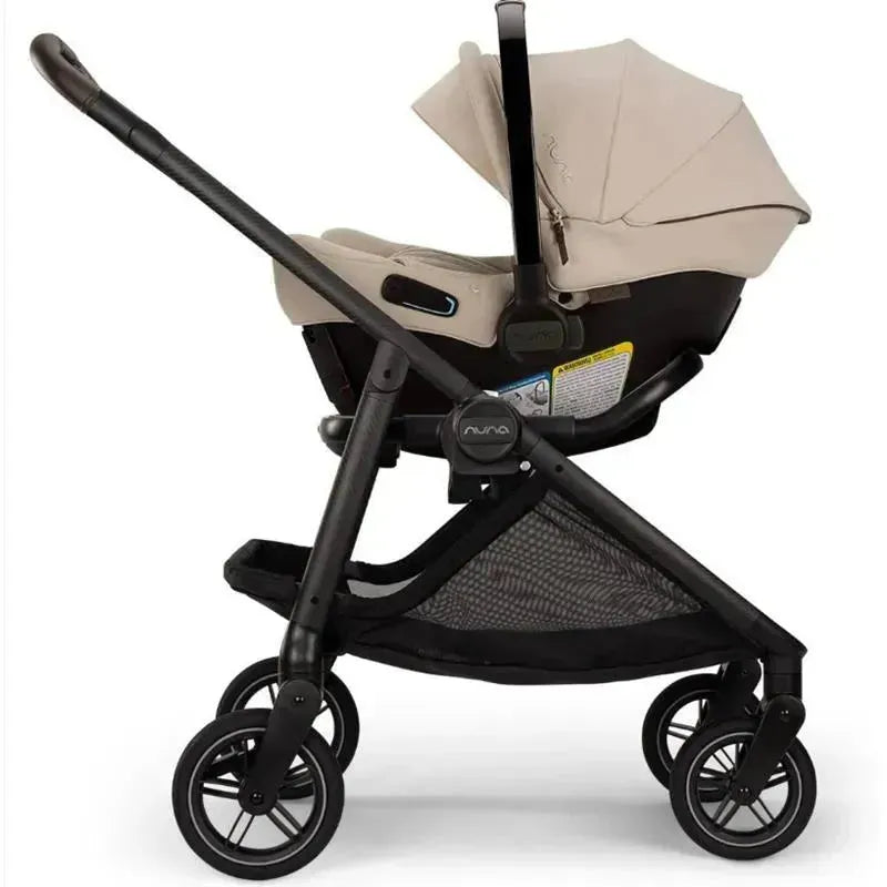 Nuna SWIV™ stroller in Biscotti color, featuring a reclining seat, adjustable handlebar, and a spacious storage basket.