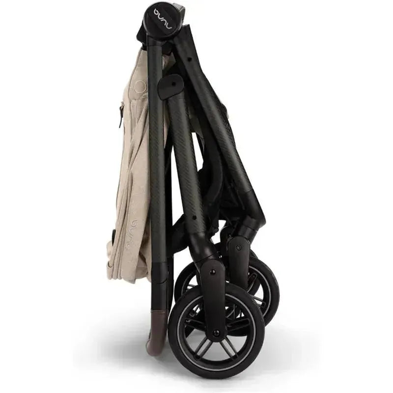 Nuna SWIV™ Stroller in Biscotti color, compactly folded with black wheels, showcasing its portable design.