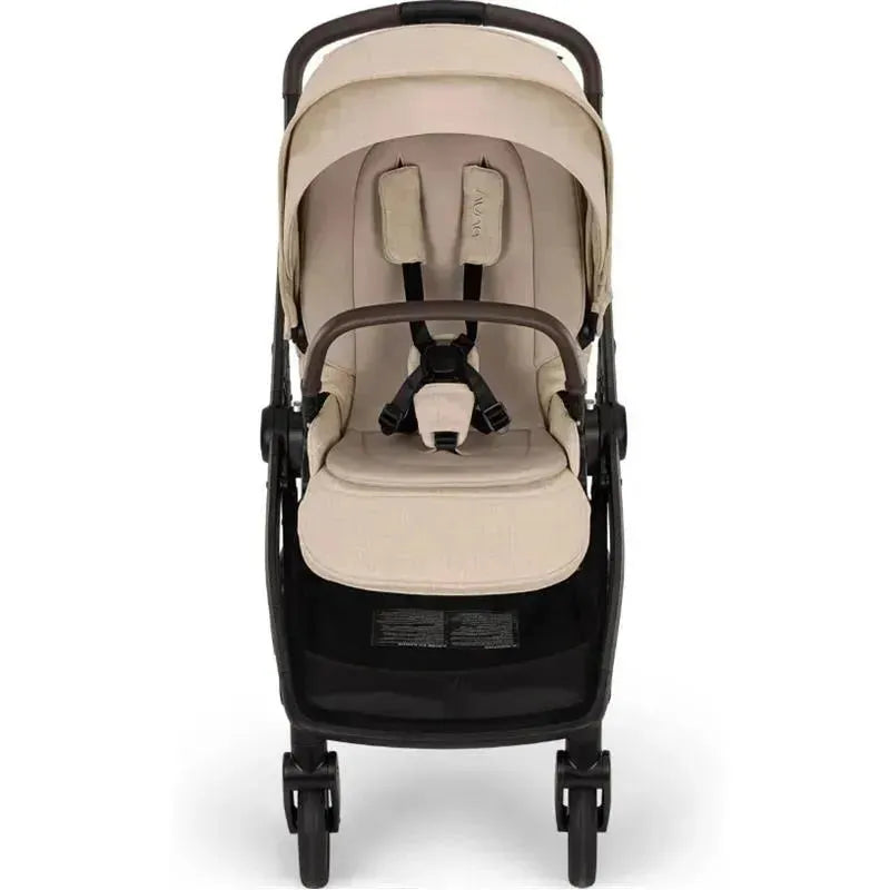 Nuna SWIV™ Stroller in Biscotti color, featuring a stylish seat with straps and a large storage basket below.