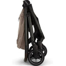 Nuna SWIV™ Stroller in Cedar color, shown in a folded position with a sleek design and compact wheels.