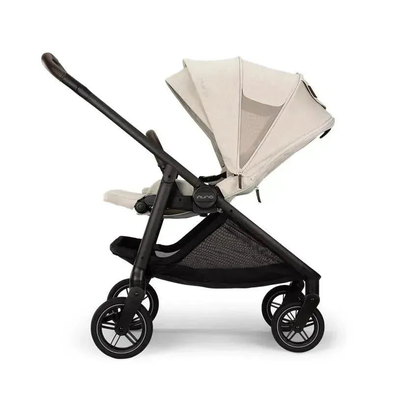Nuna SWIV™ Stroller in Chai color, featuring adjustable canopy, black frame, and four wheels.