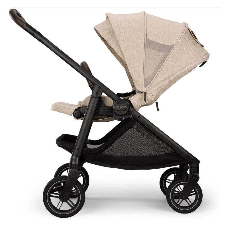 Nuna Swiv Stroller in Biscotti color with a black frame, featuring a canopy and mesh storage area.