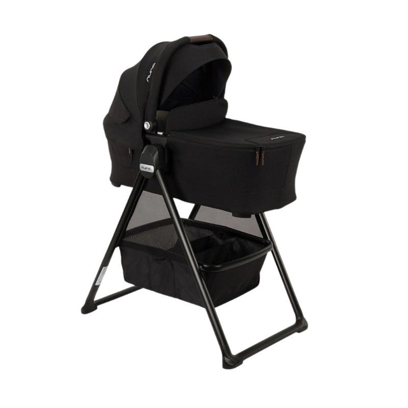 Nuna Swiv Stroller with a Caviar-colored bassinet and stand, featuring a spacious lower storage basket.
