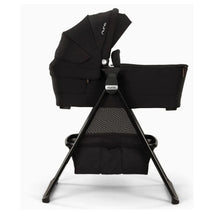 Nuna Swiv™ & Triv™ Series bassinet in caviar with chocolate accents, featuring a sturdy stand and storage mesh.