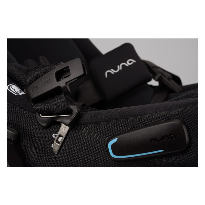 Nuna Triv Lx car seat buckle and harness detail, featuring a black fabric design with a blue accent.