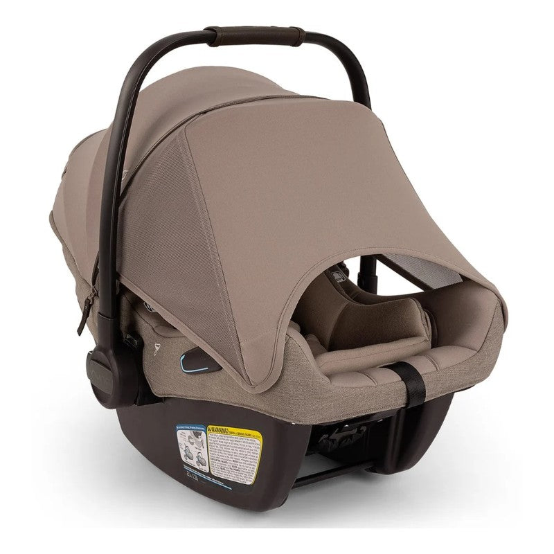 Nuna Triv Lx + Pipa Aire Rx travel system in Cedar color, showcasing the infant car seat with a protective canopy and safety label.