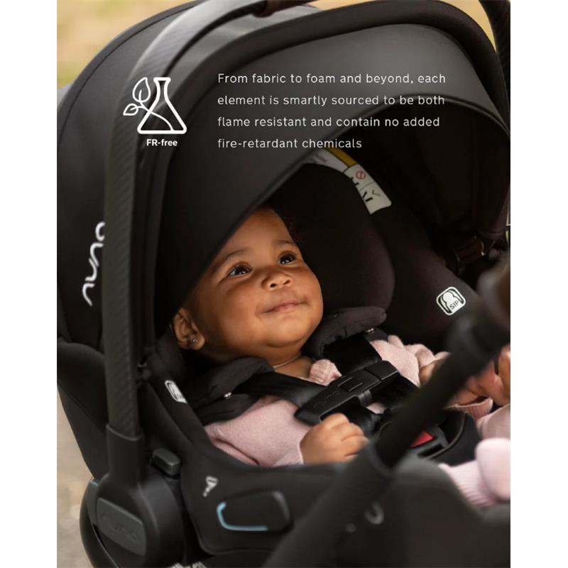 Nuna Triv Lx car seat with a smiling baby inside, featuring a flame-resistant design without added chemicals.