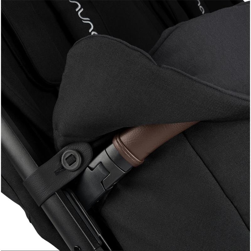 Nuna TRVL™ dubl Footmuff in Caviar, showing black fabric with brown accent and attachment details for stroller use.