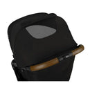 Nuna TRVL™ Stroller in caviar color, featuring a black canopy with a mesh ventilation window and a brown handlebar.