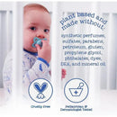 Baby holding a blue pacifier behind crib bars, with text highlighting that the product is plant-based and free from harmful ingredients.