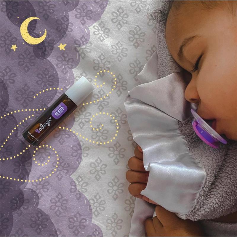 Oilogic Slumber & Sleep Essential Oil Roll-On beside a sleeping child, featuring a patterned bedding and a pacifier.