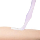 Diaper rash cream applicator dispensing cream onto a light-skinned arm, featuring a suction base design.