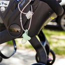 Silicone strap with a light green pacifier attached to a stroller, designed for convenience and baby safety.