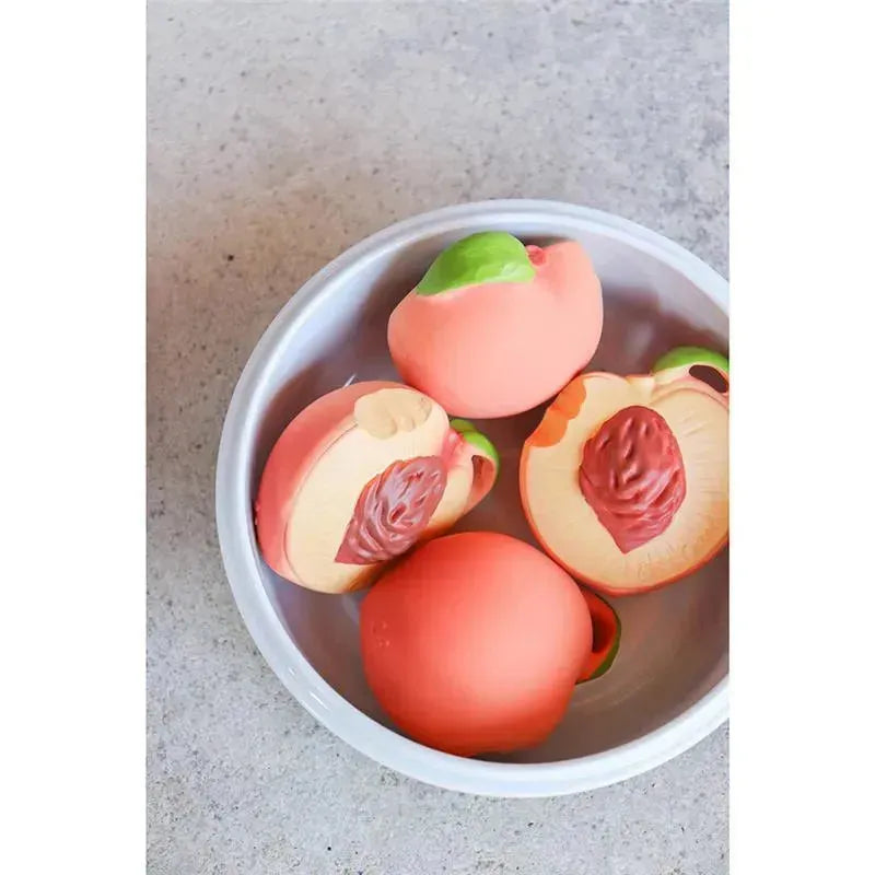 Chewable toy set from Oli & Carol featuring palm peach designs in a white bowl, showcasing realistic peach and pit details.