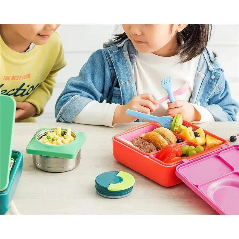 Children enjoying a meal with an OmieBox, featuring colorful dividers, fruits, and healthy snacks.