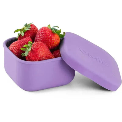 Purple OmieBox food storage container with a lid, filled with fresh strawberries.
