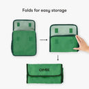 OmieBox insulated nylon lunch tote in green, demonstrating its folding feature for easy storage.