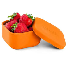 Leakproof orange silicone container with a lid, holding fresh strawberries inside.