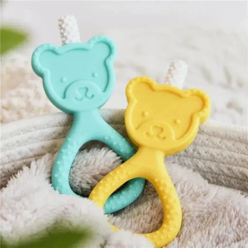 Baby teether set featuring a seafoam green and a yellow bear-shaped design, resting on a soft fabric surface.