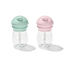 Two 9 oz Oxo Tot Transitions straw cups in opal green and blossom pink, with measurement markings on the sides.