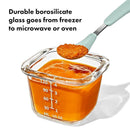 Oxo Tot Glass Baby Blocks food storage container with orange baby food, showcasing measurement markings and a spoon.