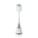 OXO Tot Bottle Brush with a white bristle cleaner, placed upright in a gray and white stand.