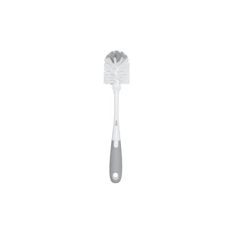 OXO Tot bottle brush with a gray handle and bristle cleaner, designed for efficient baby bottle cleaning.