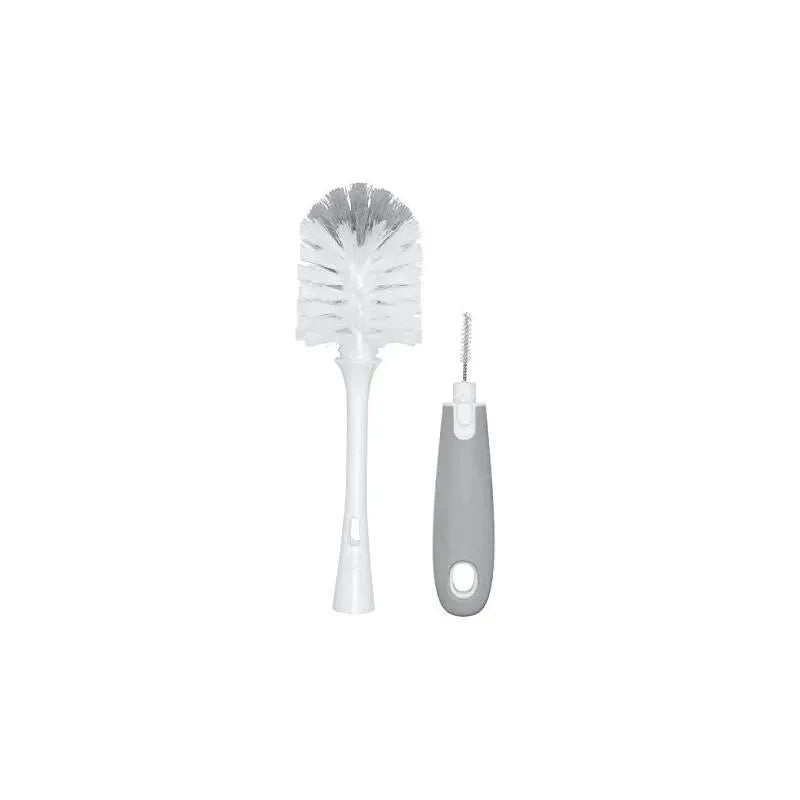 OXO Tot Bottle Brush with a white bristle head and a gray ergonomic handle, accompanied by a bristle cleaner.
