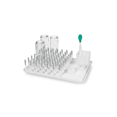 Gray OXO Tot Bottle Drying Rack with glass bottles, drying pegs, and a bottle brush holder.