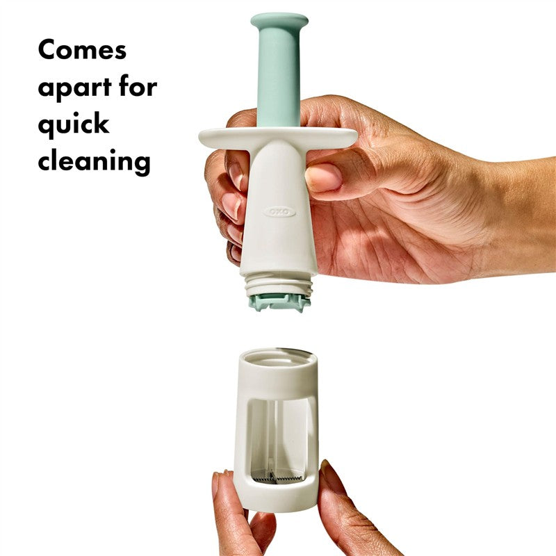 OXO Tot Grape Cutter in opal color, designed to cut grapes safely, shown in two parts for easy cleaning.