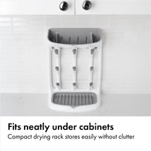 Compact gray drying rack with vertical slots for dishes, designed to fit under cabinets without clutter.