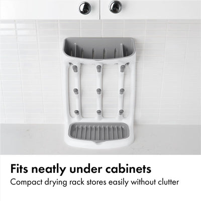 Compact gray drying rack with vertical slots for dishes, designed to fit under cabinets without clutter.