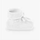 Knit baby booties in white by Paz Rodriguez, featuring a cozy design with a rolled cuff and decorative ties.