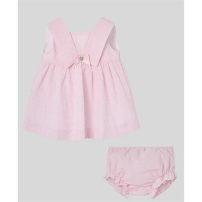 Baby dress and bloomer set in chalk pink, featuring a bow detail and textured fabric.