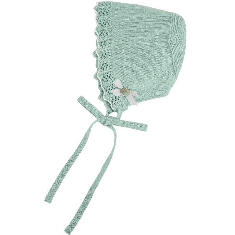 Mint green knitted baby bonnet with lace trim, a bow detail, and ties for secure fastening.