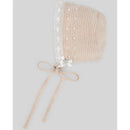 Linen and white crochet baby hat with lace trim, polka dots, and a bow, featuring ties for secure fitting.