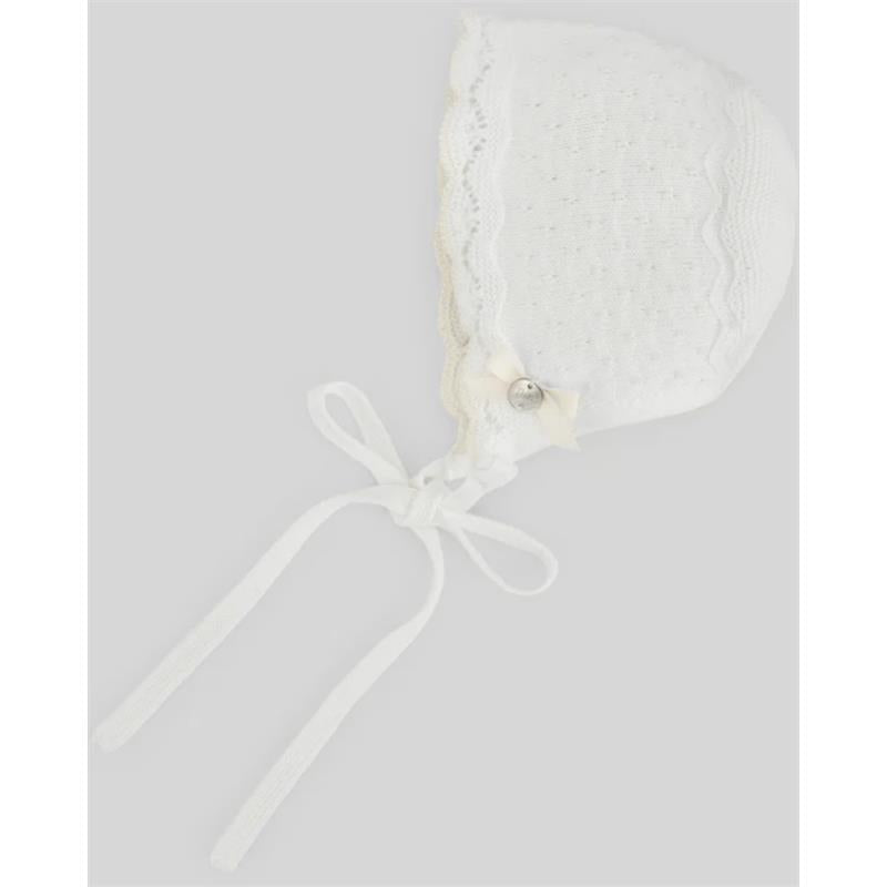 White knitted baby bonnet with lace trim, a small bow, and ribbons for tying under the chin.