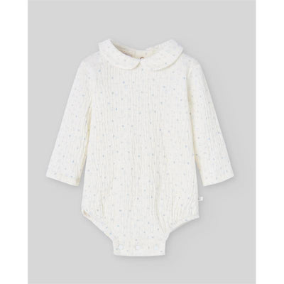 Knit newborn bodysuit in cream with powder blue speckles, featuring a rounded collar and long sleeves.