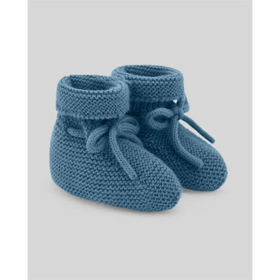 Knit newborn booties in chalk blue with a rolled cuff and ties, designed for infants.
