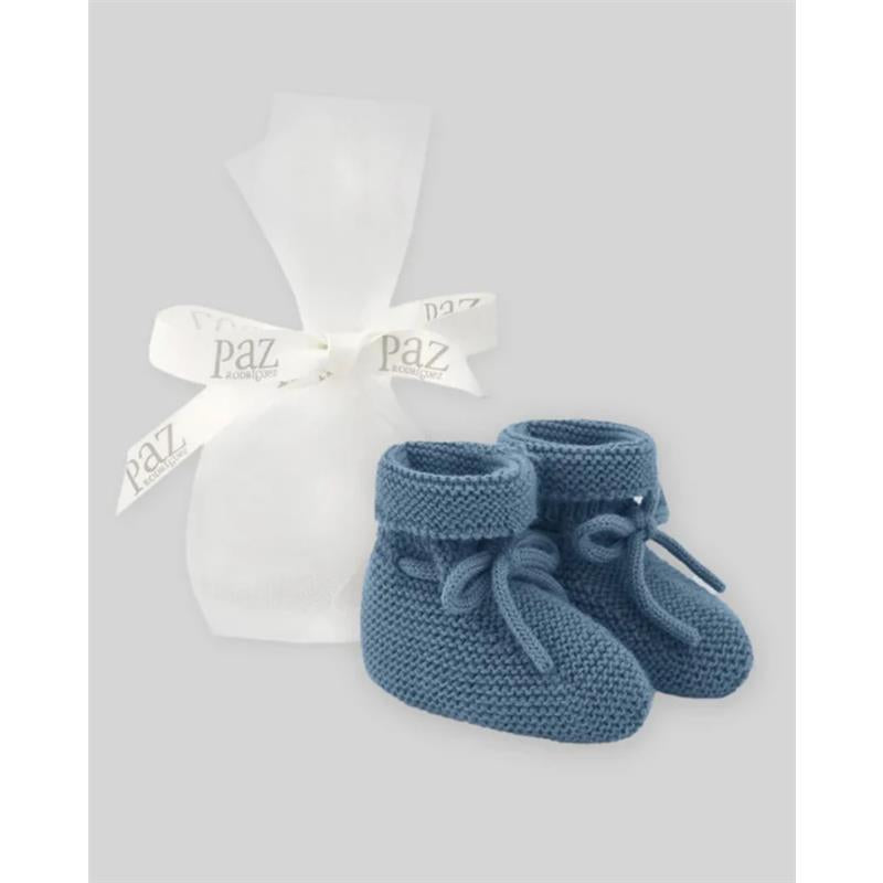 Knit newborn booties in chalk blue by Paz Rodriguez, presented with a white organza bag and ribbon.