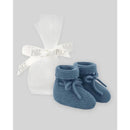 Knit newborn booties in chalk blue by Paz Rodriguez, presented with a white organza bag and ribbon.