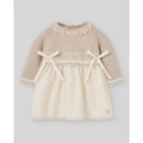 Knit newborn dress in light brown and cream, featuring lace trim and bows at the waist and neckline.
