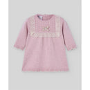 Knit newborn dress in powder pink with light brown lace trim, featuring a bow and pearl detail on the chest.