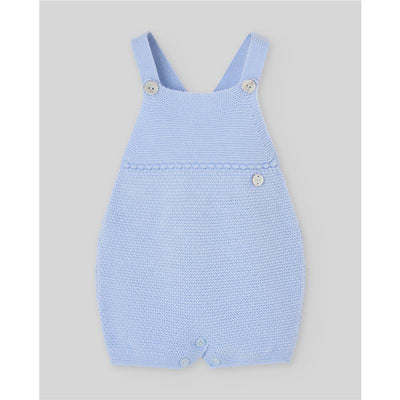 Light blue knitted dungarees for newborns, featuring buttons at the straps and bottom, designed by Paz Rodriguez.