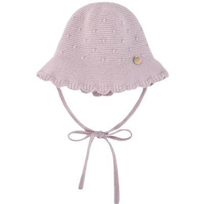 Knit newborn hat in mauve with scalloped brim and chin ties, featuring a small decorative badge.