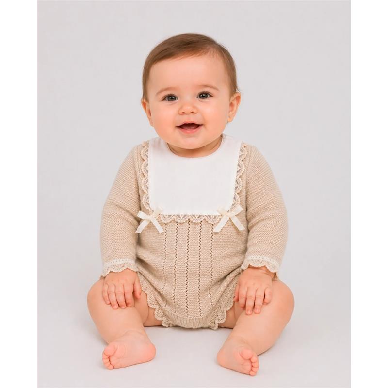 Newborn sitting and smiling, wearing a light brown and cream knit romper with a white collar and lace details.