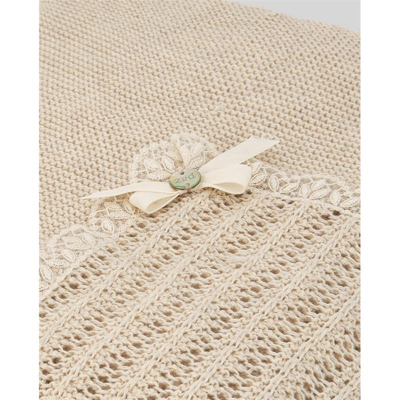 Light brown knit newborn shawl by Paz Rodriguez, featuring a floral lace trim and a decorative bow with a button.