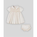 Woven newborn dress and bloomers set in cream, featuring short sleeves, a collar, and decorative smocking detail.