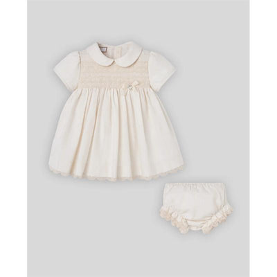 Woven newborn dress and bloomers set in cream, featuring short sleeves, a collar, and decorative smocking detail.