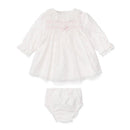 Light pink woven newborn dress with floral details and matching bloomers, featuring a ruffled collar and button accents.